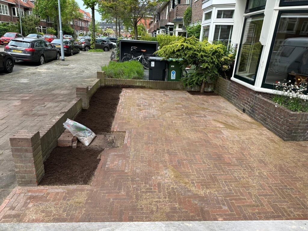 Voortuin met herbestrating in visgraatpatroon en nieuwe plantvakken